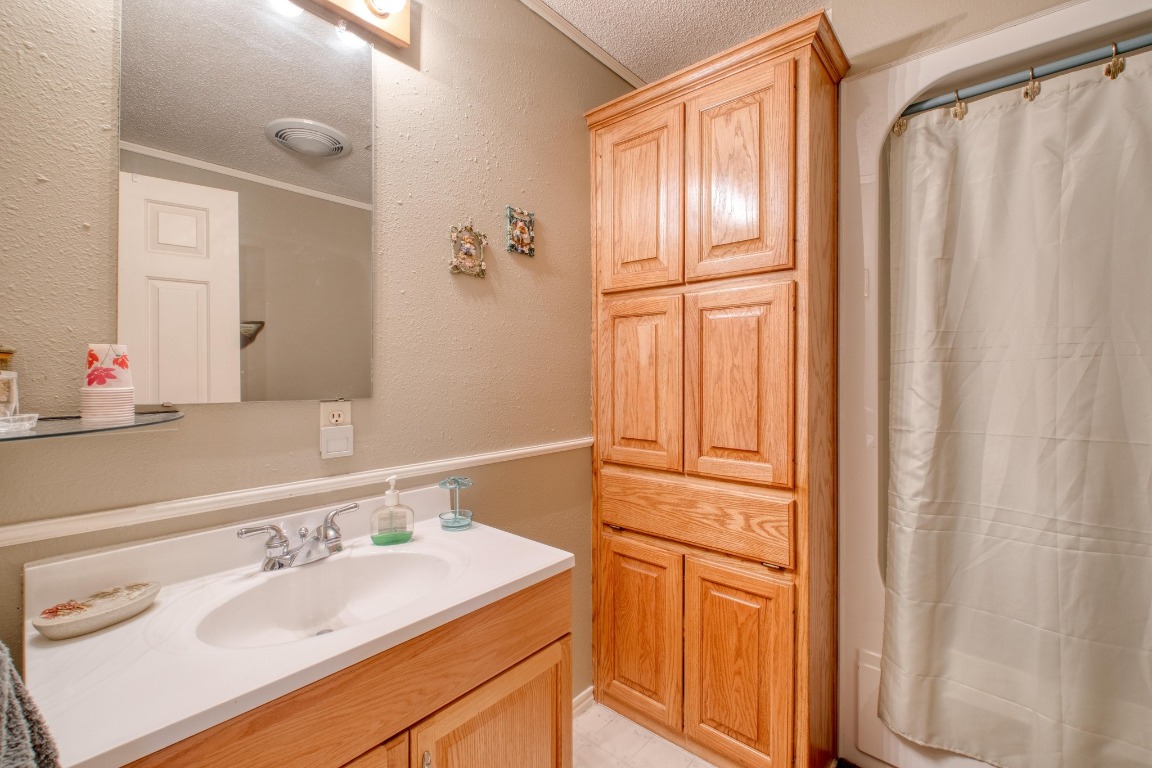 153 Pleasant Grove Road Elgin, TX 78621 - Photo 23 of 34 a bathroom with a sink a mirror and a shower