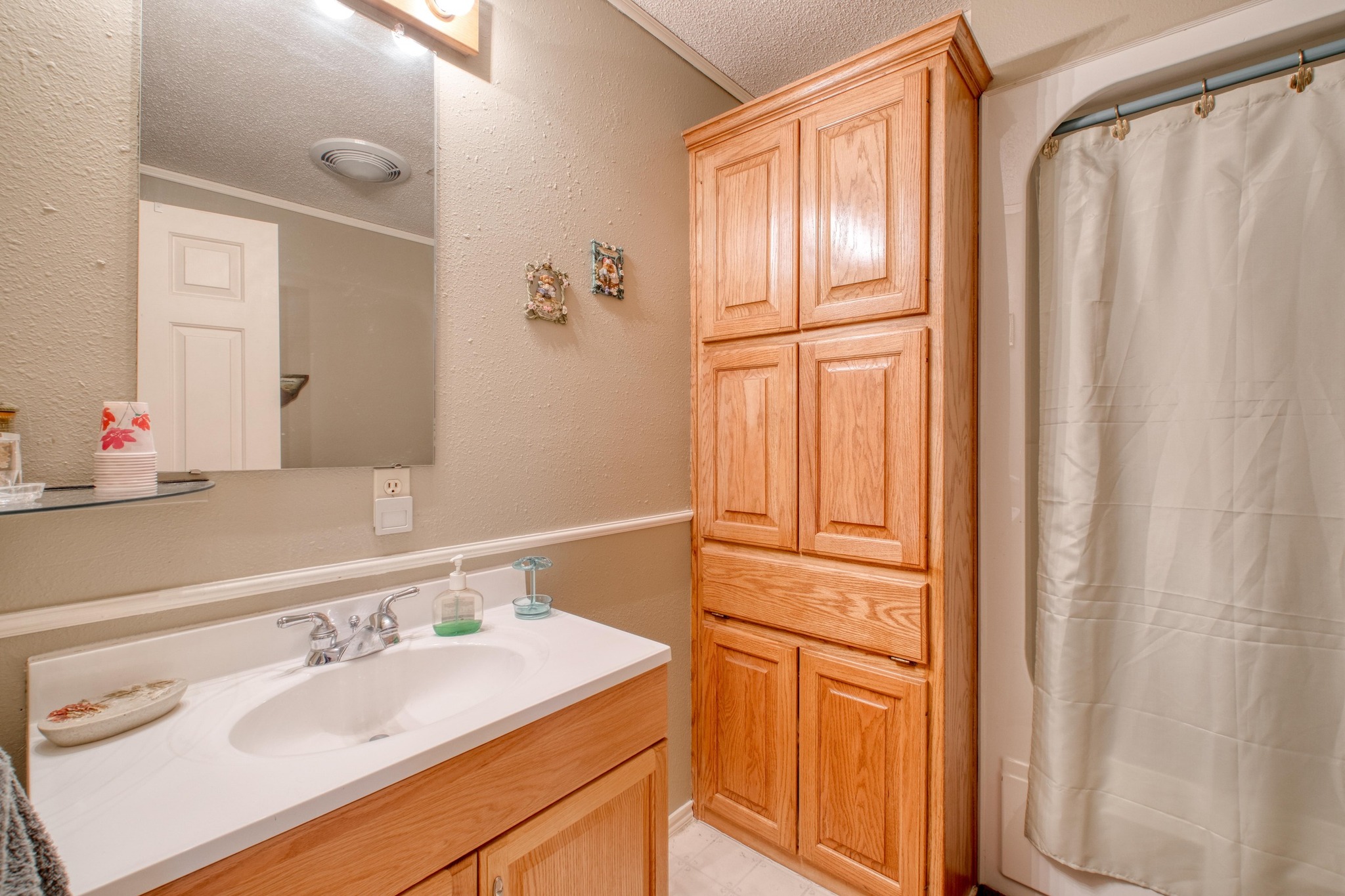 153 Pleasant Grove Road Elgin, TX 78621 - Photo 23 of 34 Full bath with a textured wall, vanity, a shower with shower curtain, and a textured ceiling