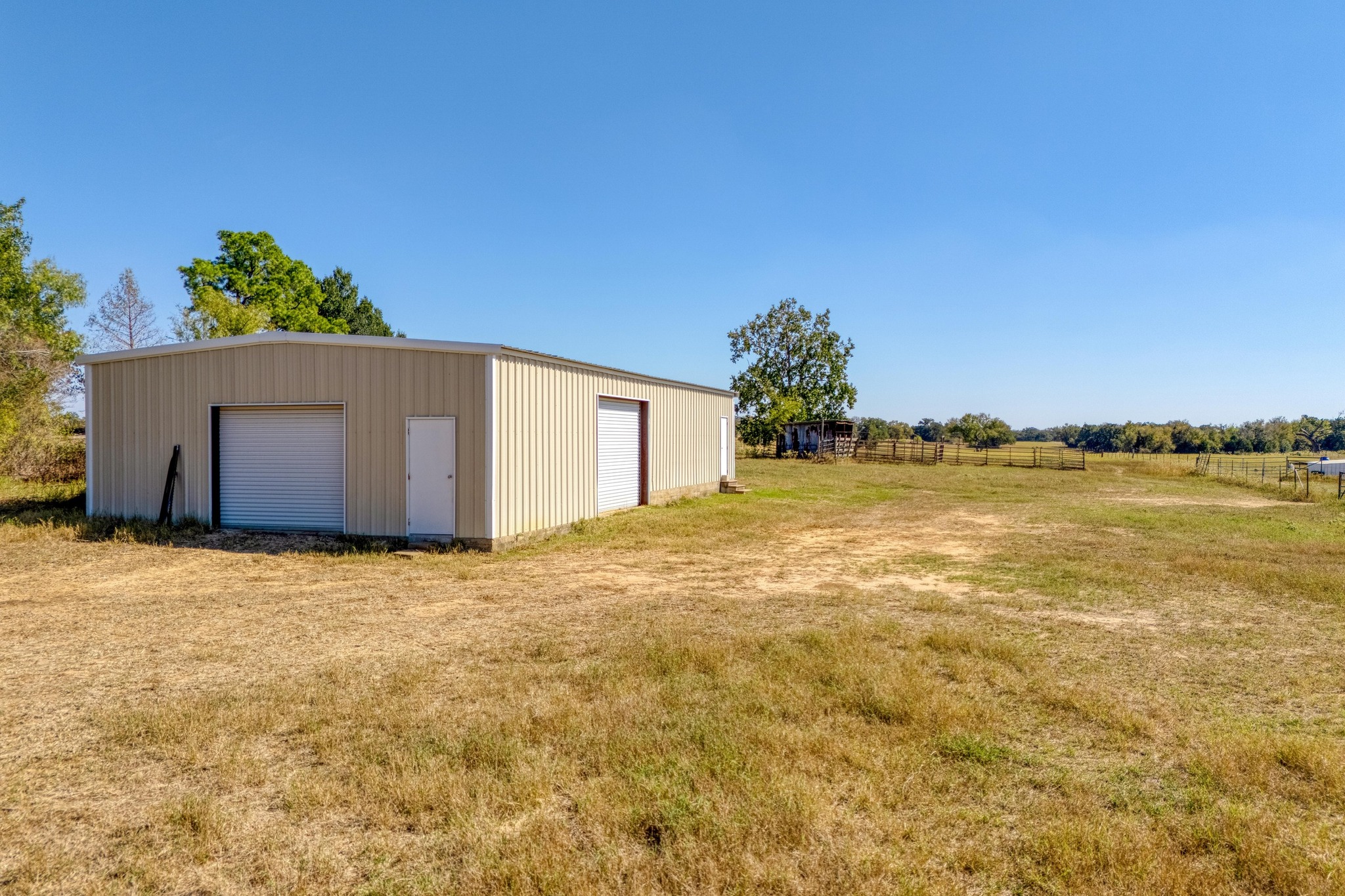 153 Pleasant Grove Road Elgin, TX 78621 - Photo 27 of 34 View of yard featuring an outbuilding, a garage, and a view of countryside