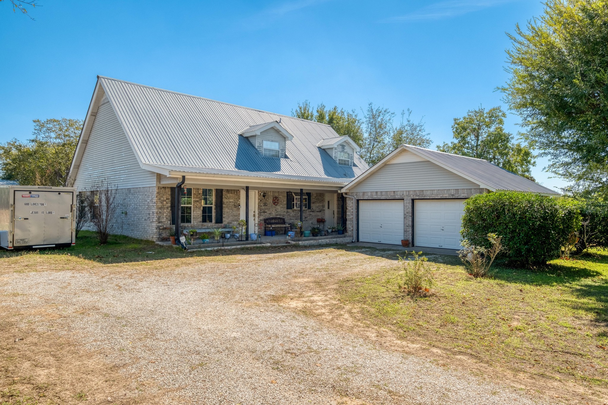 153 Pleasant Grove Road Elgin, TX 78621 - Photo 3 of 34 Cape cod home with dirt driveway, covered porch, brick siding, and a front yard