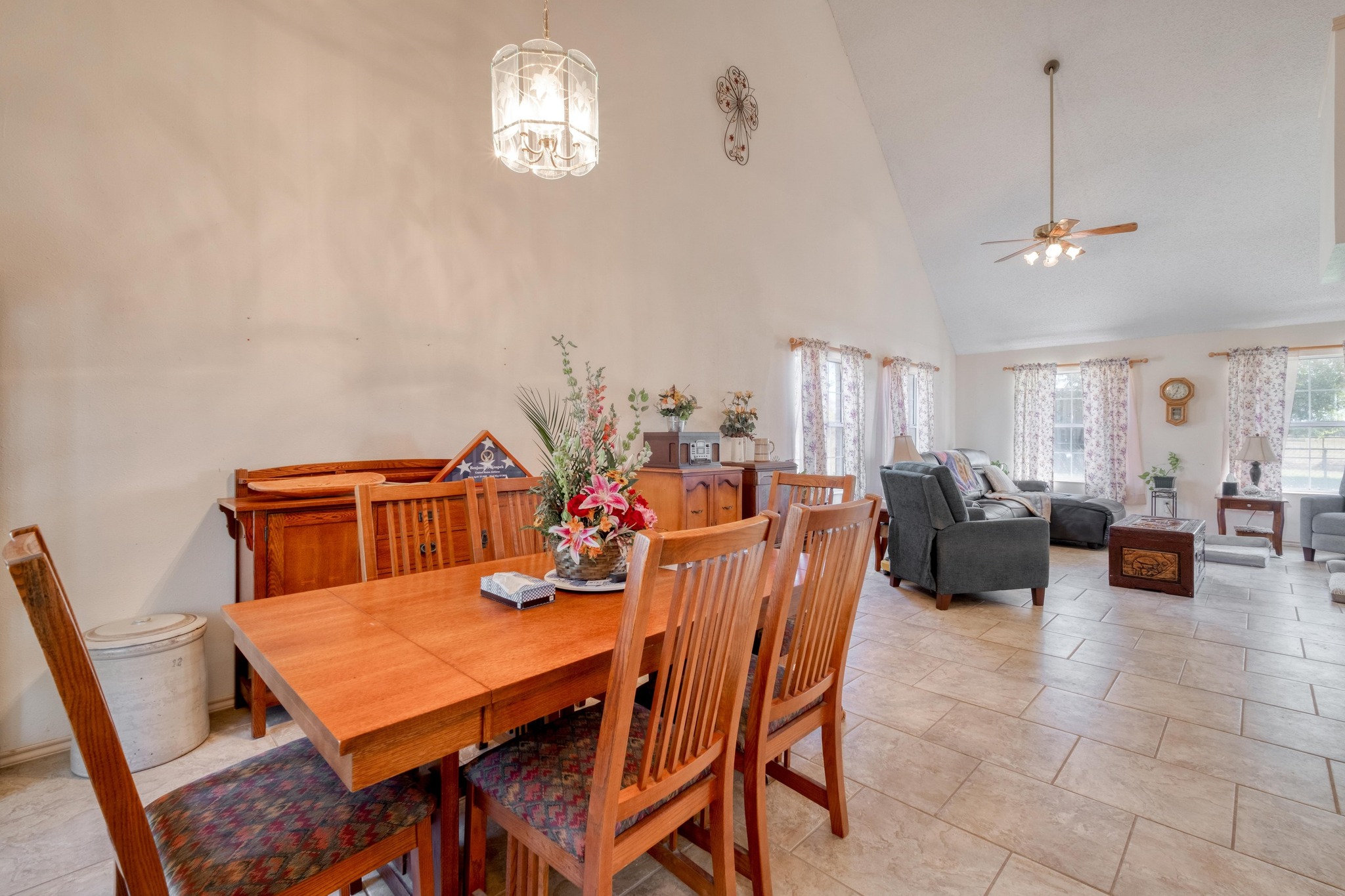 153 Pleasant Grove Road Elgin, TX 78621 - Photo 10 of 34 Dining room with high vaulted ceiling, ceiling fan, light tile patterned floors, and a chandelier