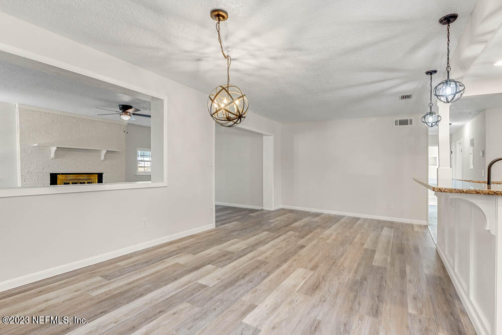 4066 Ferrarra Street Jacksonville, FL 32217 - Photo 11 of 25 a view of a room with a chandelier and wooden floor