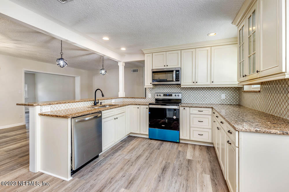 4066 Ferrarra Street Jacksonville, FL 32217 - Photo 12 of 25 a kitchen with granite countertop a sink cabinets and stainless steel appliances