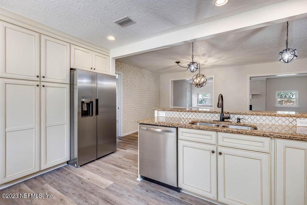 4066 Ferrarra Street Jacksonville, FL 32217 - Photo 13 of 25 a kitchen with kitchen island granite countertop a sink cabinets and stainless steel appliances