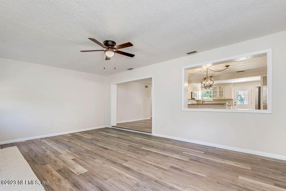 4066 Ferrarra Street Jacksonville, FL 32217 - Photo 15 of 25 a view of a big room with wooden floor and a chandelier fan