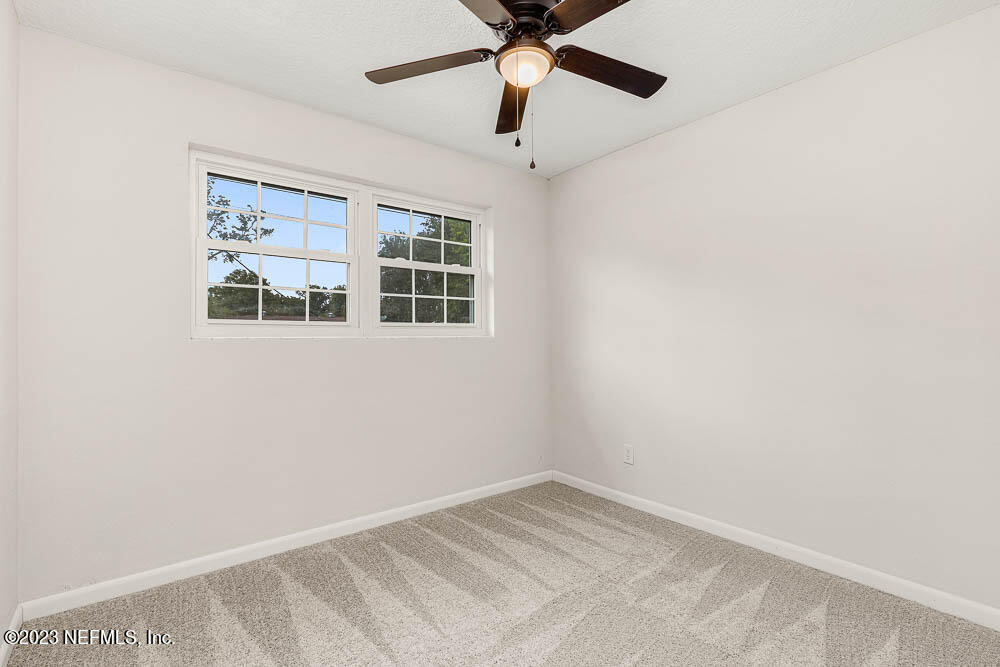 4066 Ferrarra Street Jacksonville, FL 32217 - Photo 18 of 25 a view of empty room with wooden floor and fan