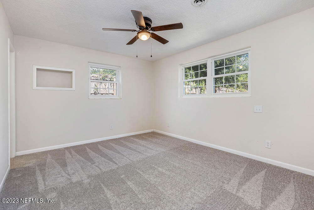 4066 Ferrarra Street Jacksonville, FL 32217 - Photo 20 of 25 an empty room with ceiling fan and window