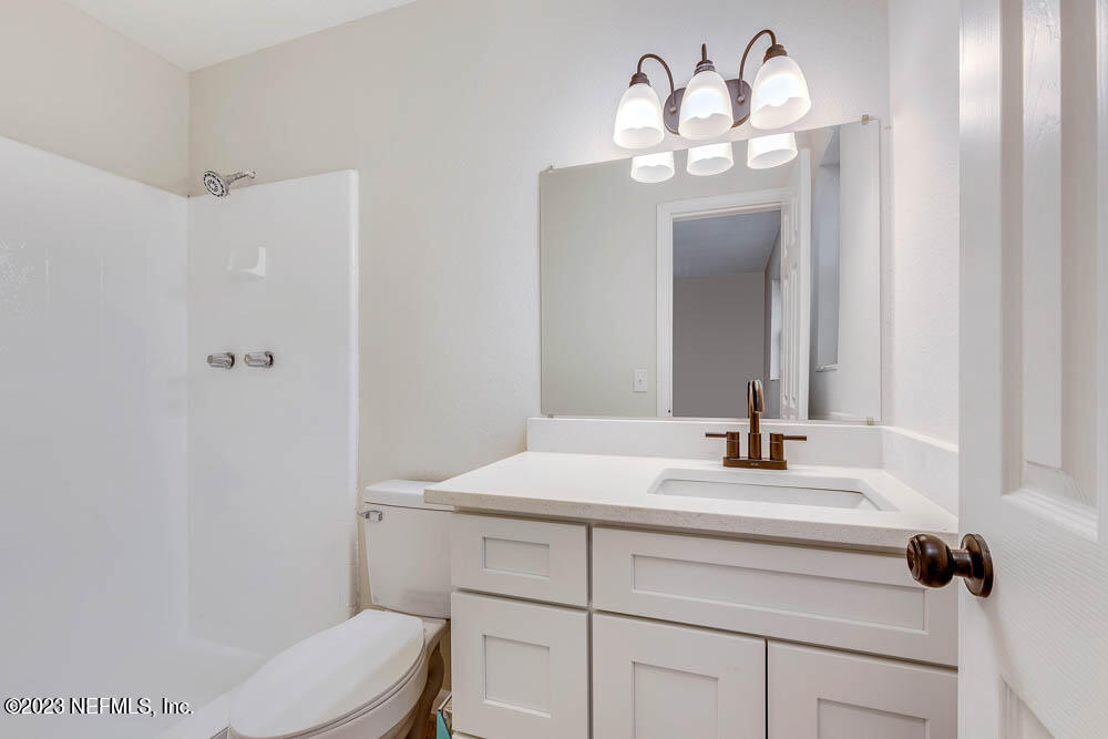 4066 Ferrarra Street Jacksonville, FL 32217 - Photo 4 of 25 a bathroom with a sink vanity mirror and toilet