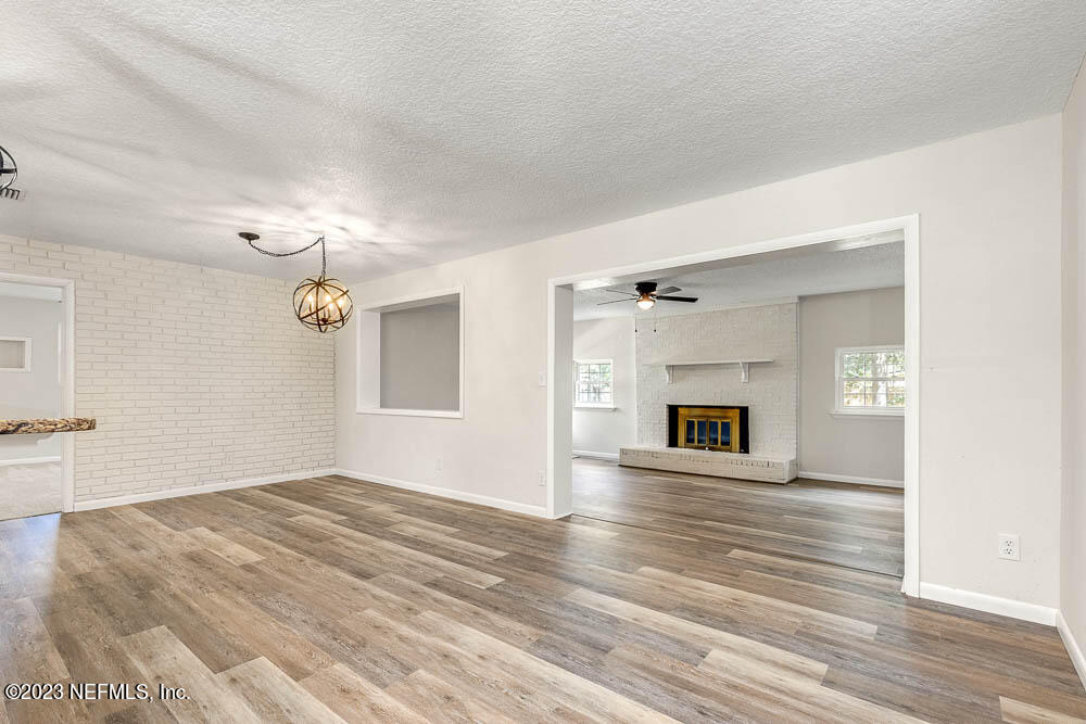 4066 Ferrarra Street Jacksonville, FL 32217 - Photo 9 of 25 an empty room with wooden floor fireplace and windows