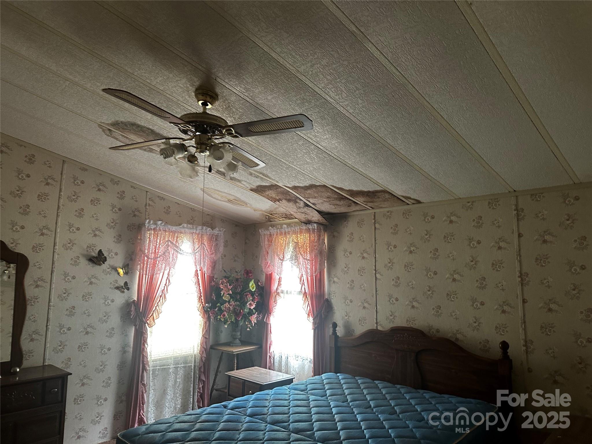 731 Pigeon Roost Road Green Mountain, NC 28740 - Photo 12 of 31 a bedroom with a bed and a chandelier
