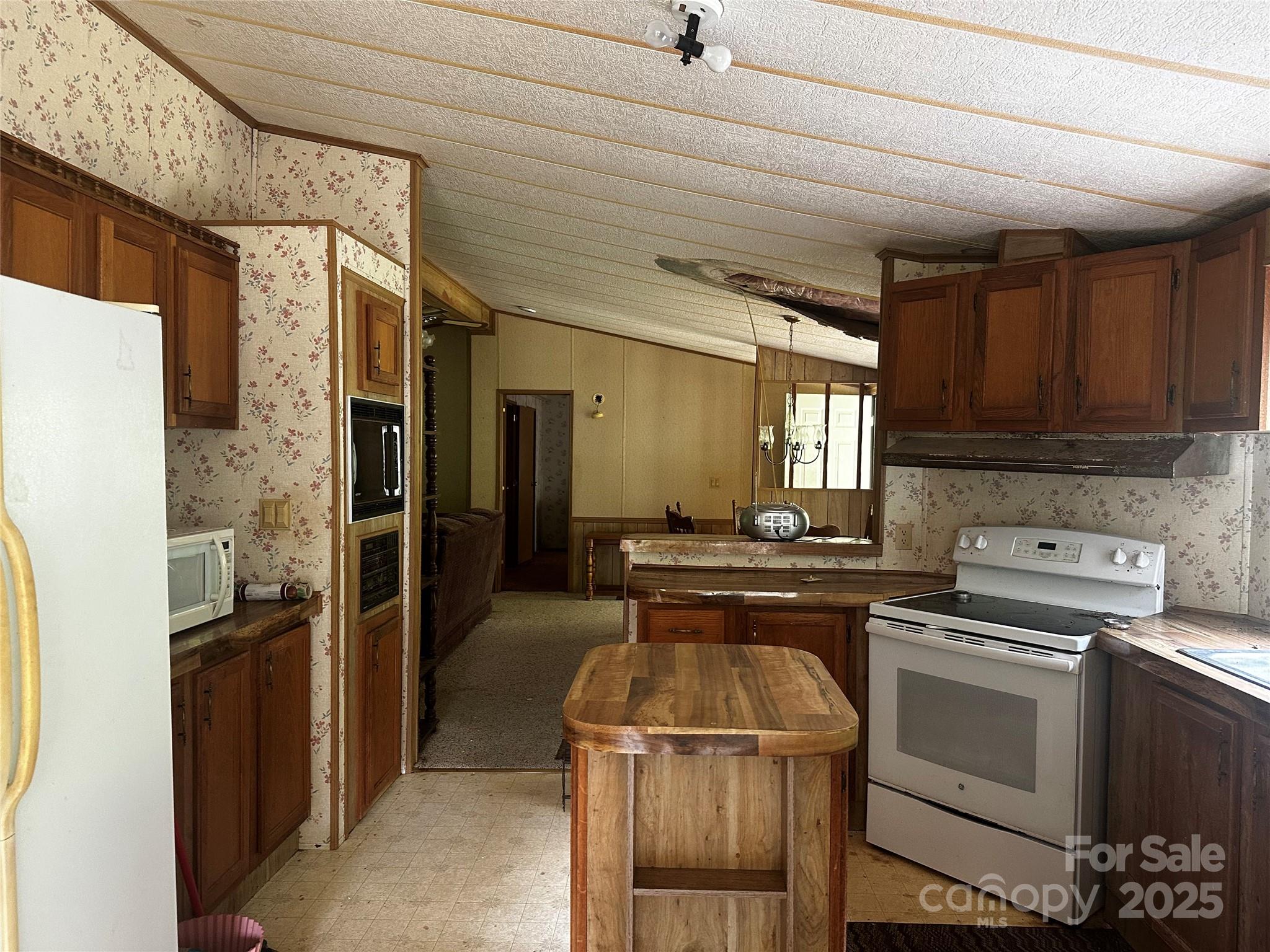 731 Pigeon Roost Road Green Mountain, NC 28740 - Photo 6 of 31 a kitchen with a stove a refrigerator and cabinets