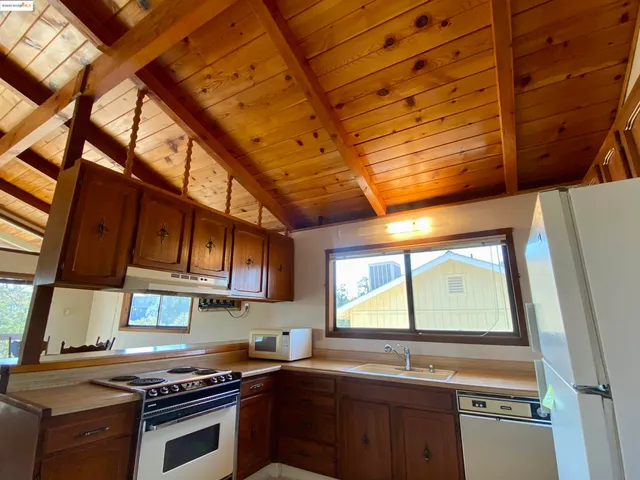 a kitchen with stainless steel appliances a sink dishwasher a stove and a microwave oven