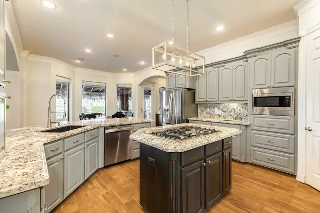 a kitchen with stainless steel appliances granite countertop a stove and a refrigerator