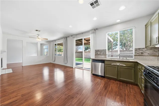 a kitchen with stainless steel appliances granite countertop wooden floors and sink