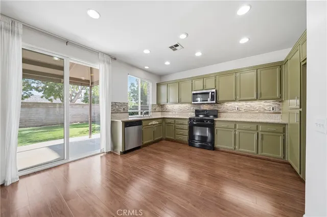 a kitchen with stainless steel appliances granite countertop a stove sink and cabinets