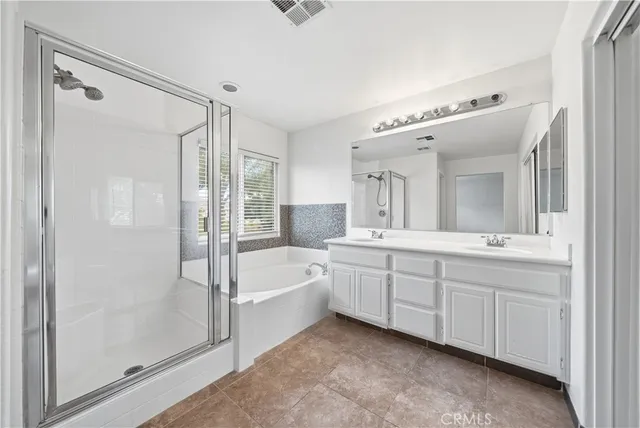 a spacious bathroom with a double vanity sink a mirror and a bathtub