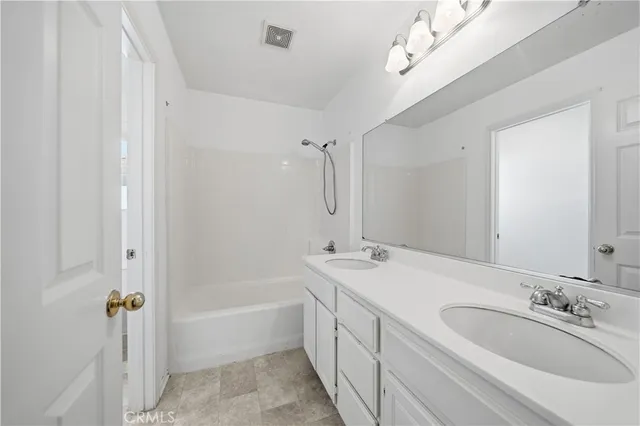 a bathroom with a tub a sink and mirror