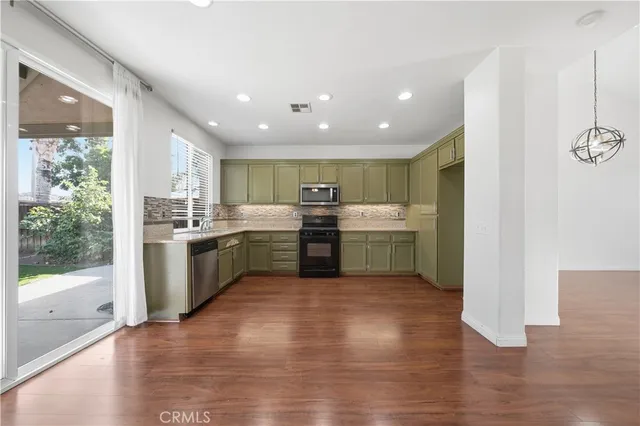 a kitchen with a sink cabinets and wooden floor
