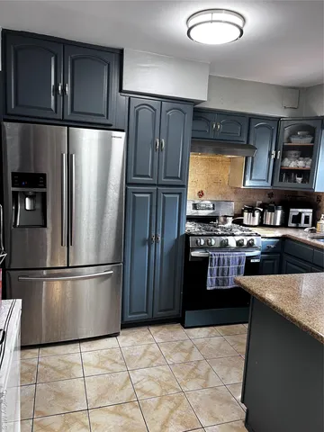 a kitchen with stainless steel appliances granite countertop a refrigerator stove and microwave