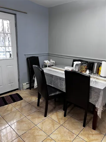 a room with a table chairs and a window