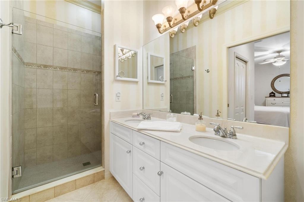 8610 Cedar Hammock Circle, Unit 1242 Naples, FL 34112 - Photo 16 of 50 a bathroom with a shower sink and mirror
