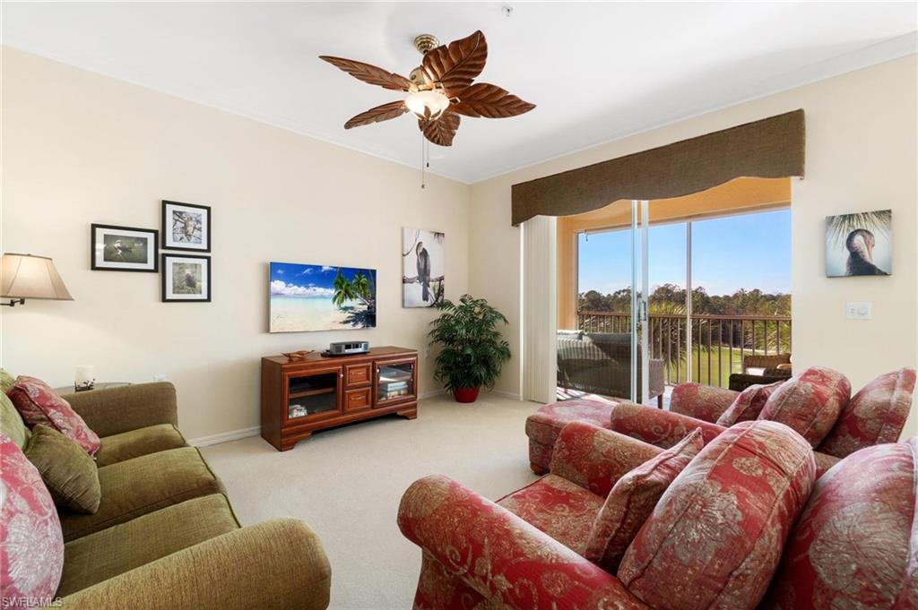 8610 Cedar Hammock Circle, Unit 1242 Naples, FL 34112 - Photo 22 of 50 a living room with furniture a ceiling fan and a large window