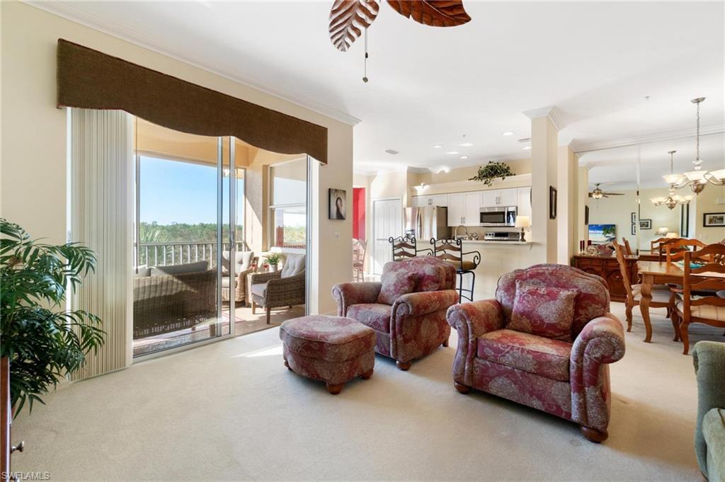 8610 Cedar Hammock Circle, Unit 1242 Naples, FL 34112 - Photo 25 of 50 a living room with furniture and a floor to ceiling window