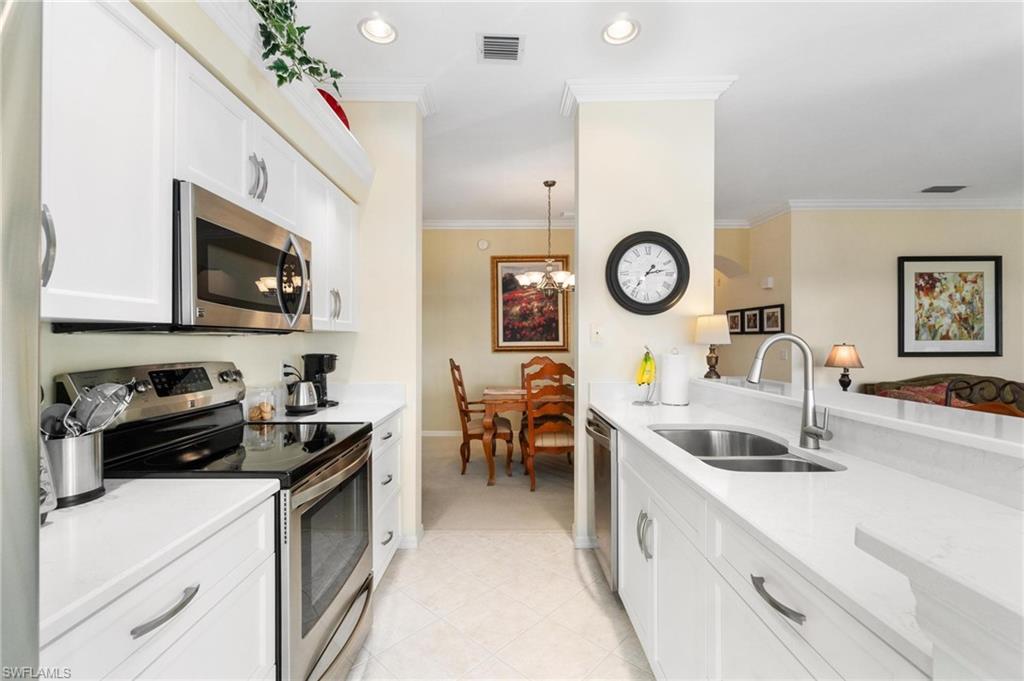 8610 Cedar Hammock Circle, Unit 1242 Naples, FL 34112 - Photo 32 of 50 a kitchen with a sink a stove cabinets and living room view