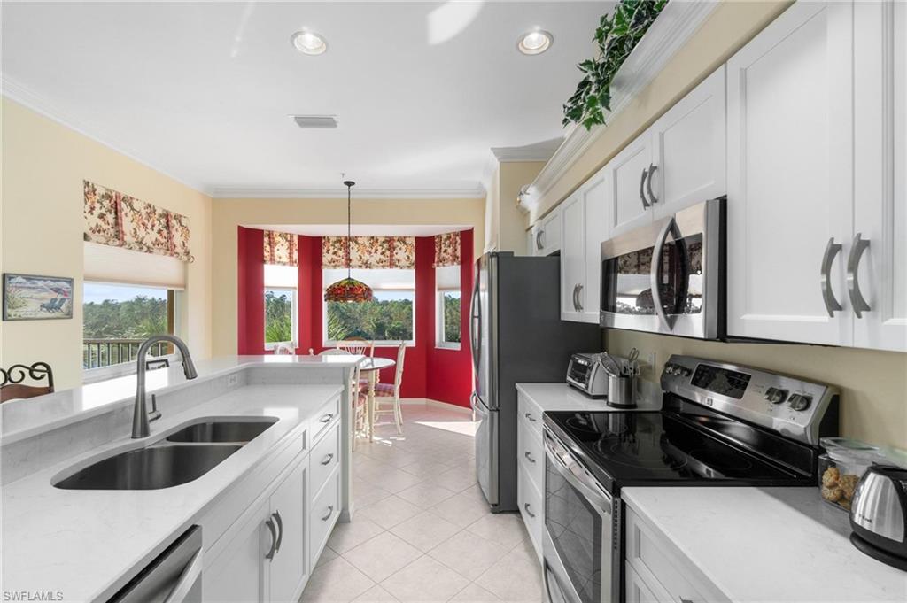 8610 Cedar Hammock Circle, Unit 1242 Naples, FL 34112 - Photo 33 of 50 a kitchen that has a sink and a stove