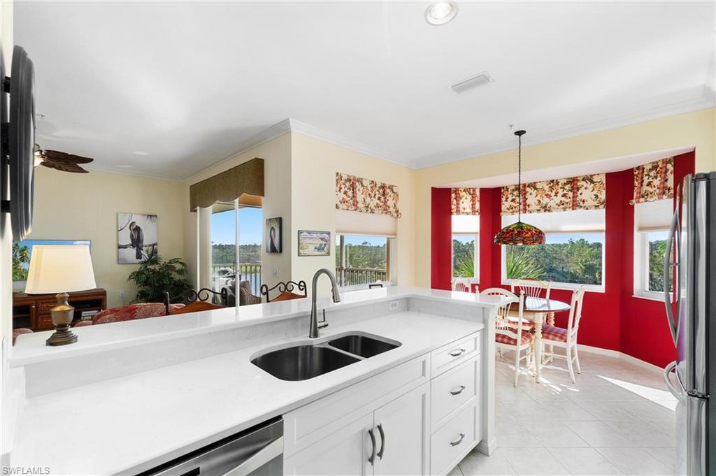 8610 Cedar Hammock Circle, Unit 1242 Naples, FL 34112 - Photo 34 of 50 a kitchen with stainless steel appliances a sink and a large window