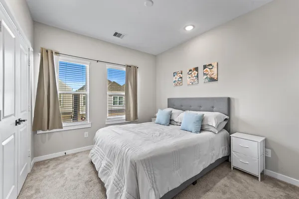 a bedroom with a bed and a large window