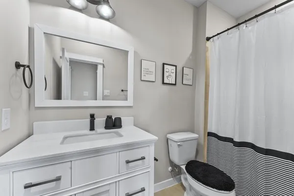 a bathroom with a sink a toilet and a mirror