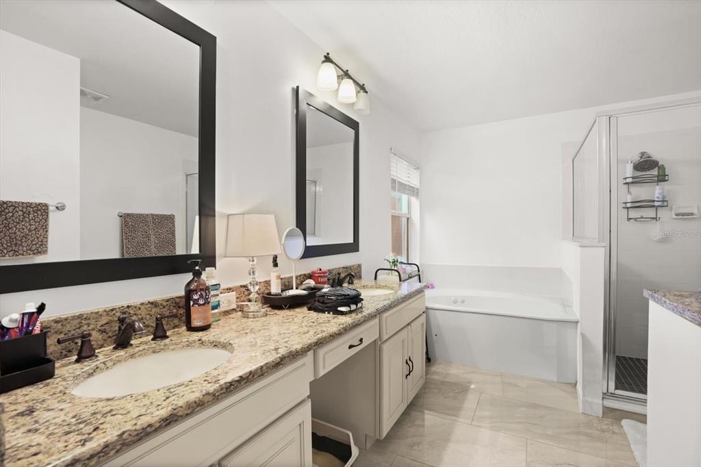 248 Longhirst Loop Ocoee, FL 34761 - Photo 12 of 30 a bathroom with a granite countertop sink mirror and a bathtub
