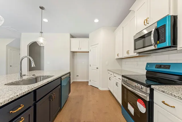 a kitchen with stainless steel appliances granite countertop a sink and a stove