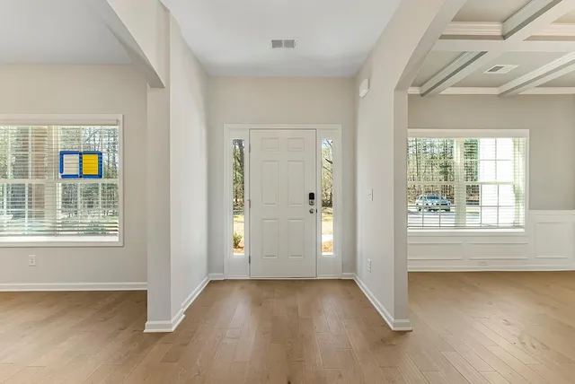 an empty room with wooden floor and windows