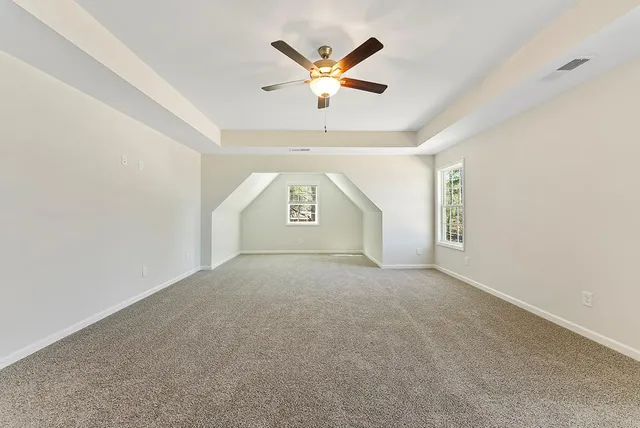 an empty room with window and ceiling fan