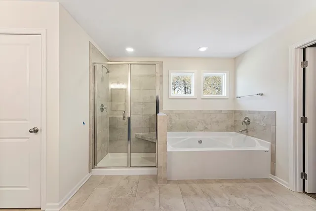 a spacious bathroom with a bathtub and shower