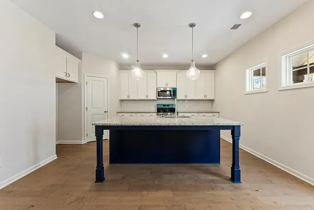 a view of kitchen with refrigerator stove center island and wooden floor