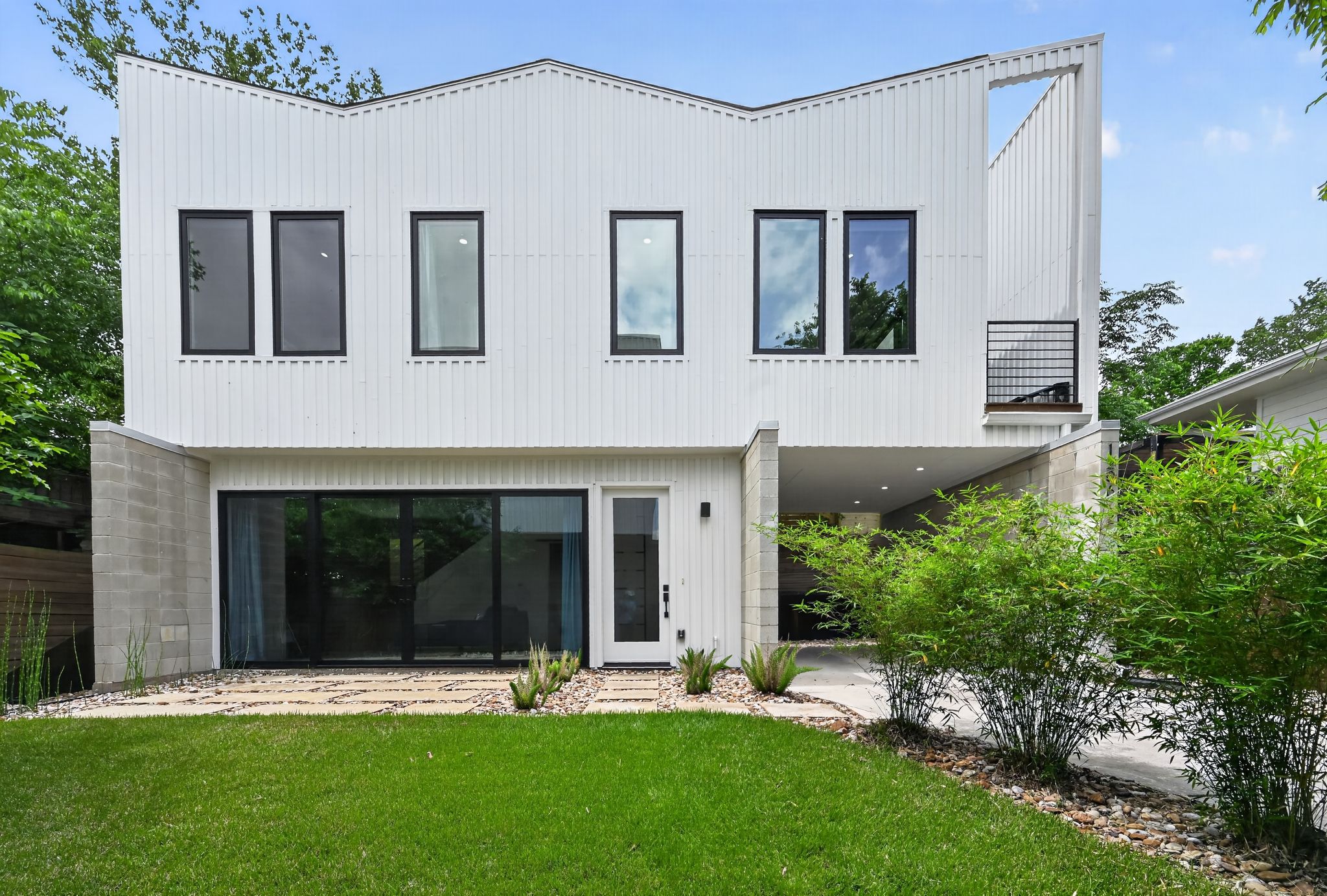 The property features a contemporary architectural style with a white facade and black-framed windows