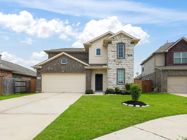 a front view of a house with a garden and yard