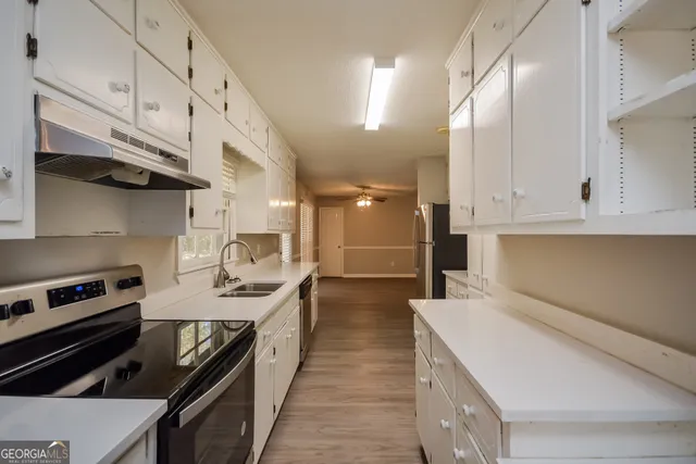 a kitchen with a stove and a white cabinets