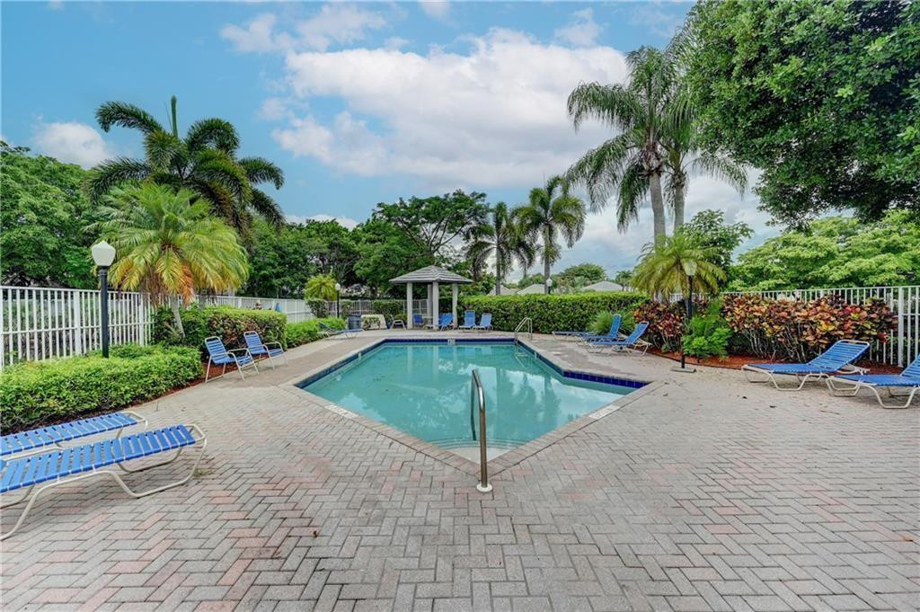 8171 Hampton Wood Drive Boca Raton, FL 33433 - Photo 30 of 56 a view of a swimming pool with a yard