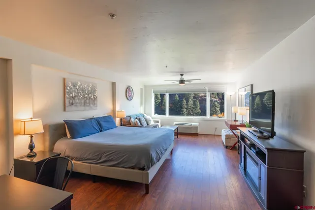 a bedroom with a bed and a flat screen tv