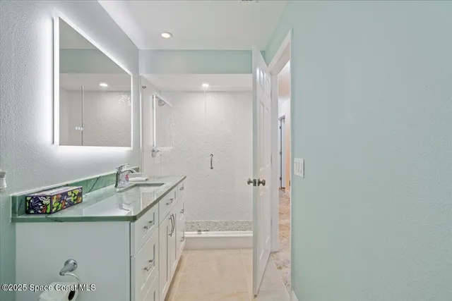a bathroom with a granite countertop sink a mirror and a shower