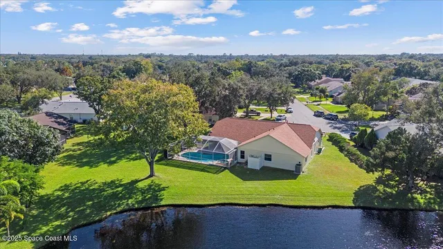 an aerial view of residential houses with outdoor space and trees