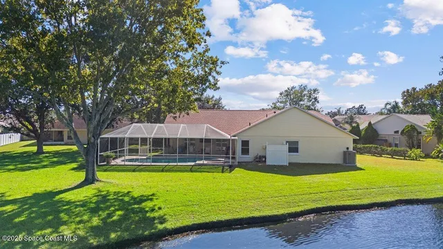 a view of a house with a big yard potted plants and large tree