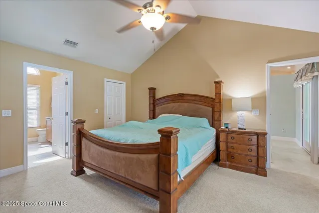 a bedroom with a bed a chandelier and a dresser