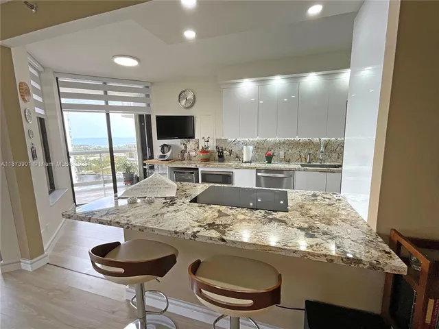 a dining room with furniture and a floor to ceiling window