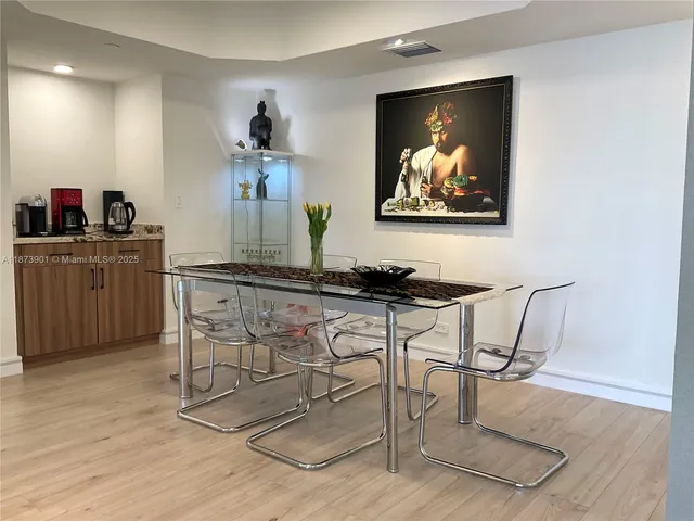a living room with furniture a kitchen island a sink and a painting on the wall