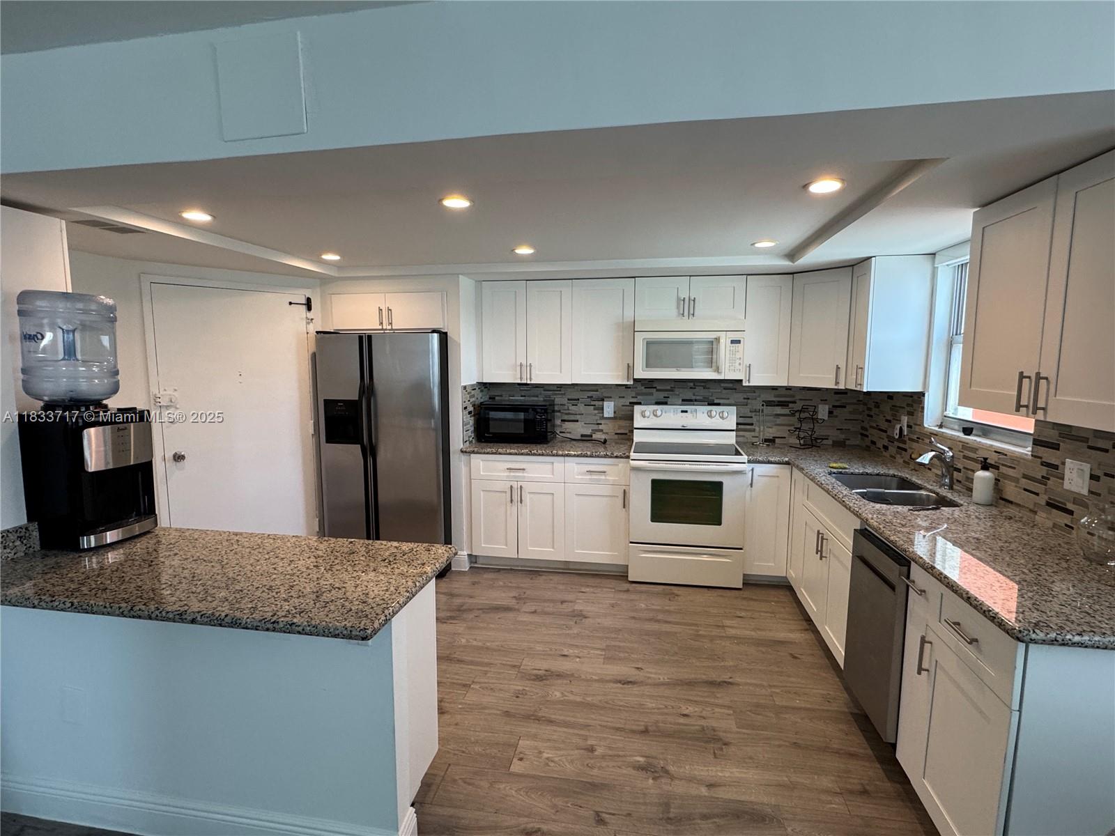 Buckley Towers Miami, FL 33179 - Photo 4 of 18 a large kitchen with stainless steel appliances granite countertop a stove a sink and a refrigerator